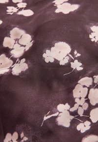Tessuto con motivo floreale in viola scuro con fiori rosa chiaro. Texture morbida, finitura liscia, caratterizzato da diverse forme di fiori e sfumature delicate.