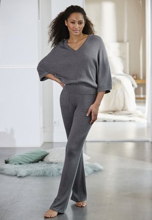 Grijze gebreide lounge set met een losse V-hals top en flare broeken met een getextureerd ribbelontwerp en voorzakken.