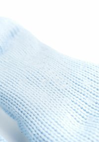 Calzino lavorato a maglia di colore azzurro chiaro con un motivo testurizzato, che presenta un polsino a costine e un tessuto liscio e morbido. Nessun logo o marchio visibile.