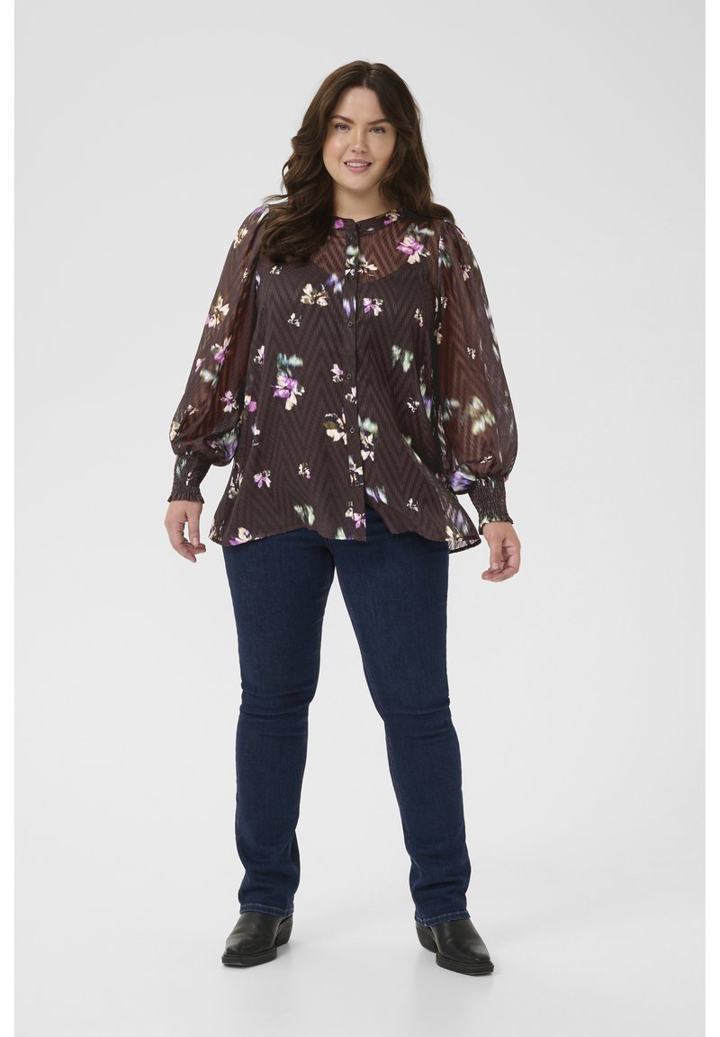 Dark floral blouse with sheer material, puffed sleeves, and button front, paired with dark denim jeans and black ankle boots.