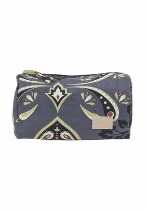 Bolsa de tela gris oscuro con patrones florales de cachemira en verde y rojo y un pequeño parche beige etiquetado con "VERDE" en la parte frontal.