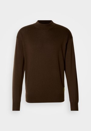 Jersey marrón de punto con un cuello alto y mangas largas. Presenta puños acanalados y un pequeño acento en neón amarillo en el lado.