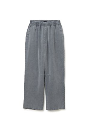 Graue weit geschnittene Hose, elastischer Bund, zwei Seitentaschen, weicher Textil, und dezentes Branding-Detail auf der Vorderseite.