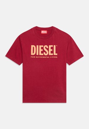 Червена тениска с къс ръкав и кръгло деколте, с голям бежов текст "DIESEL" и по-малък текст "FOR SUCCESSFUL LIVING" отпред.