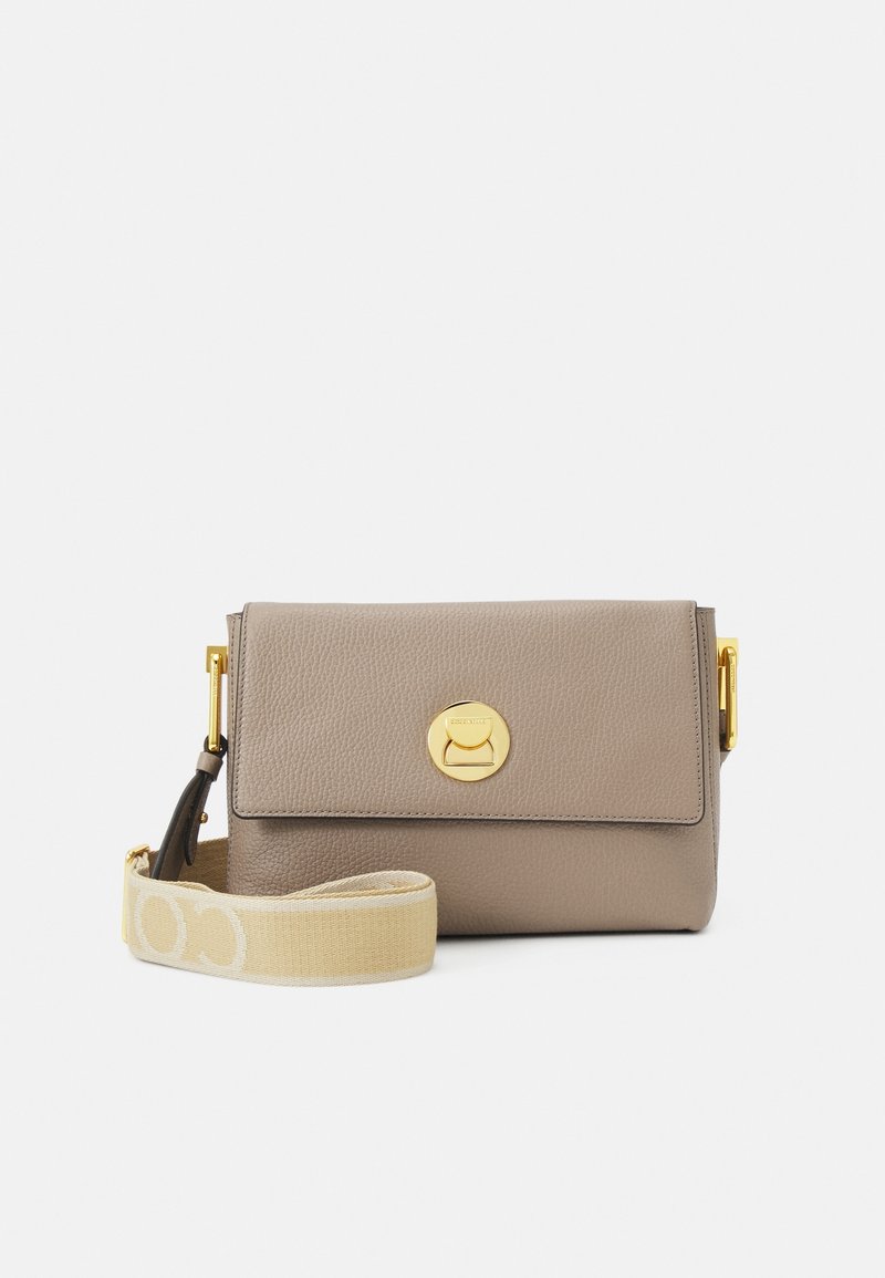 Borsa a tracolla in pelle beige con patta pieghevole, hardware circolare dorato e tracolla crema con un motivo logo sottile.