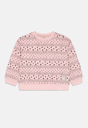 Rozā kapuci ar melniem punktu rakstiem horizontālās svītrās, ribinātām piedurknēm un noapaļotu kakla izgriezumu. Mazs birkas zīmogs apakšējā kreisajā stūrī.