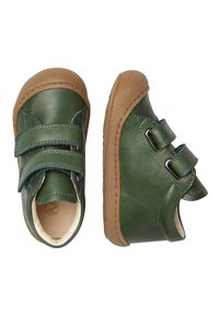 Scarpe in pelle verde con due cinturini in velcro, suole in gomma color sabbia, forma arrotondata e dettagli di cucitura visibili. Texture liscia con un design classico.
