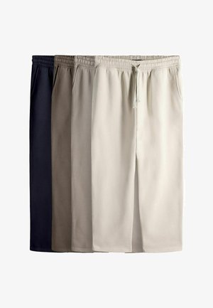 Neljä paria collegehousuja eri sävyissä: tummansininen, hiekanvärinen, vaaleabeige ja kerma. Jokaisessa on joustava vyötärönauha ja taskut.