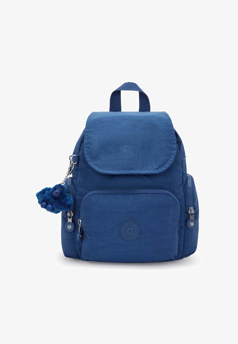 Blue fabric backpack with front and side zip pockets, top flap, short handle, and a small plush keychain attached to the left side.