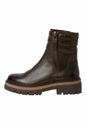 Bottine en cuir vert foncé avec une fermeture éclair sur le côté, une tige texturée et une semelle robuste avec une bande d'accent marron. Présente des détails piqués.