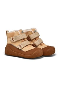 Des bottes en tissu tan présentent des sangles velcro beige, une doublure douce et des semelles extérieures en caoutchouc marron avec des grips texturés. Design simple, hauteur de la cheville.