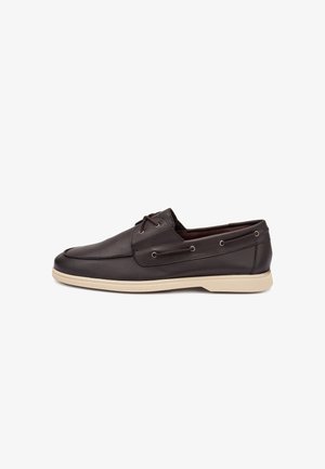 Mocassin décontracté en cuir marron foncé pour homme avec des détails en lacets et une semelle en caoutchouc beige, vue latérale sur fond blanc.