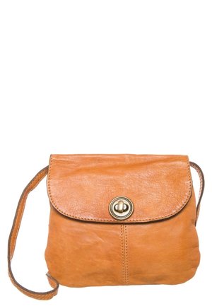 Tan leather crossbody bag with front flap and round brass twist-lock clasp, stitched details, and long matching shoulder strap.
