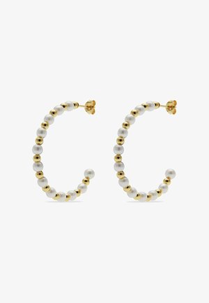 Gouden creolen met afwisselend witte parels en gouden kralen, vastgemaakt met vlinderslotjes op een witte achtergrond.