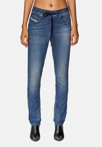 Denim joggers in medium blue with a drawstring waist, two front pockets, and tapered legs, featuring a faded texture and subtle stitching details.