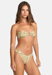 Bikini set s bezramenným topom s detailom uzla v prednej časti v olivovo zelenej farbe s bielymi kvetinovými a geometrickými vzormi; zodpovedajúce nízko predné spodné diely.