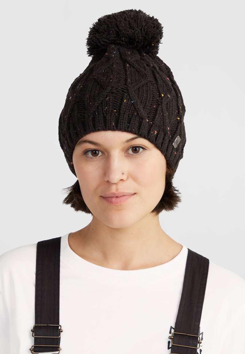 Cappello a maglia nero con un motivo a treccia testurizzato e macchie colorate, completato da un pom-pom soffice. Dettaglio del logo in metallo visibile.
