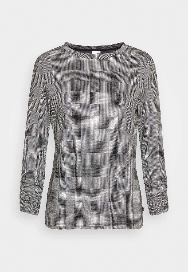Chemise à manches longues avec motif à carreaux noir et blanc comportant de petits motifs géométriques, col rond et détails froncés aux manches.