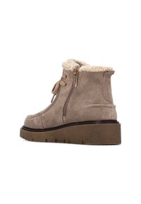 Botas tobilleras de gamuza marrón con forro de peluche, cremallera lateral, cierre de cordones y suela de goma gruesa y texturizada.