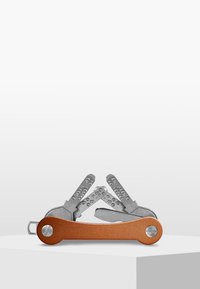 Multiverktyg med en metallisk silverfinish och ett orange texturerat handtag. Utan en mängd vikbara verktyg arrangerade i en kompakt design.