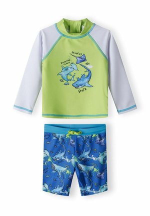 Zielony longsleeve z długim rękawem z niebieskimi akcentami, ozdobiony grafiką rekinów, w komplecie z niebieskimi szortami kąpielowymi zdobionymi wzorem rekinów i sznurkiem do regulacji.