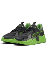 Svart och gröna sneakers med överdel i nätmaterial, gummisula och distinkta texturerade detaljer. Innehåller en logotagg och kontrasterande färgband.