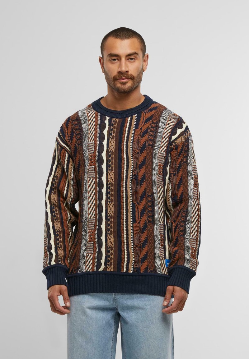 Maglione lavorato a maglia con un motivo testurizzato nei toni del marrone, crema e blu scuro, con polsini e bordo a coste, scollatura rotonda e vestibilità rilassata.