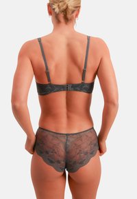 Charcoal gray lace bra and matching panties featuring floral patterns, adjustable straps, and scalloped edges, showing a semi-sheer texture.
