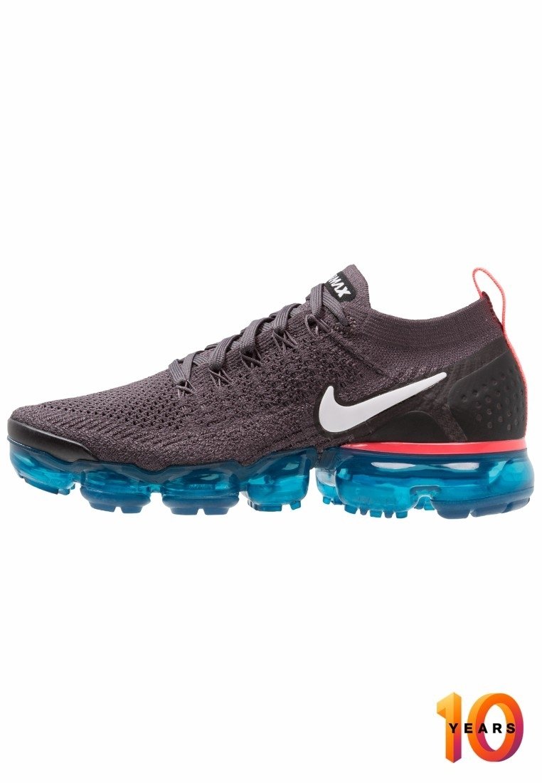 Chaussure de course Nike gris foncé avec semelle à coussin d'air bleue, logo swoosh blanc, languette de tirage rouge au talon et emblème "10 ans" dans un coin.