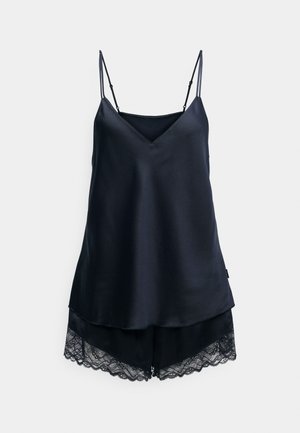 Camisole negru din satin cu bretele ajustabile și decolteu în V, asortat cu pantaloni scurți cu dantelă ondulată la margine.