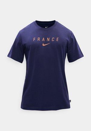 Tengerészkék Nike póló "FRANCE" felirattal és barack színű pipával a mellkasán, rövid ujjú, kerek nyakú.