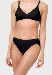 Schwarzes kabelloses Bra mit glatter Oberfläche und verstellbaren Trägern; passende hochgeschnittene schwarze Unterhose mit gewellten Kanten.