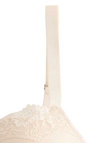 Cinghie del reggiseno color crema con bordo in pizzo floreale, slider regolabile e coppe in tessuto liscio visibili su uno sfondo bianco.