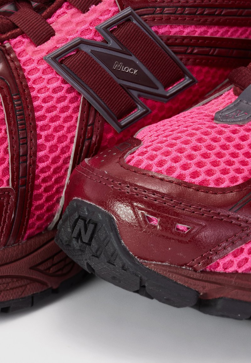 Pink mesh athletic shoes with burgundy leather accents and a black rubber sole. Features N-lock branding and detailed stitching.