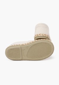 Scarpa in stile espadrilles beige con rifiniture in juta intrecciata, parte superiore in tela e suola in gomma testurizzata. Presenta un tacco piatto e dettagli cuciti.