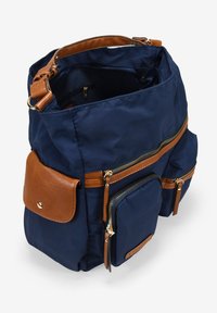 Mochila de tela azul marino con múltiples compartimentos con cremallera y acentos de cuero marrón. Cuenta con un asa superior y correas de hombro ajustables.