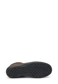 Calzature in suede marrone con suola in gomma nera testurizzata, caratterizzata da un motivo ondulato per una migliore aderenza e un design semplice. Nessun marchio visibile.
