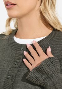 Oliwkowy sweter w robótce z ryżowym kołnierzem i mankietami, z zapięciem na guziki i teksturowanym wzorem. Bawełniana warstwa pod spodem.