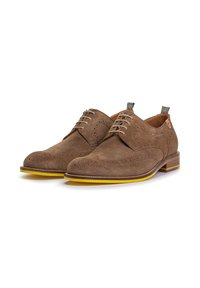 Bruine suède derby schoenen met een wingtip ontwerp, perforaties, gele zool en lichtbruine veters. De achterhak heeft een stoffen lusdetail.