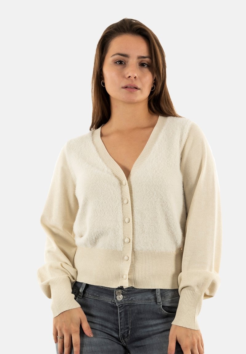 Cardigan crema con scollo a V e pannello centrale a trama, polsini a costine e sei bottoni sul davanti. Tessuto morbido a maglia.