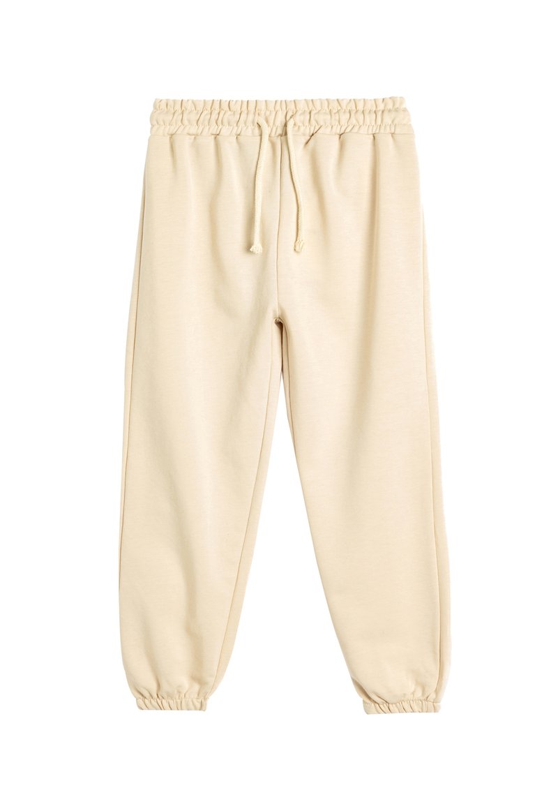 Beige sweatsuitit, jossa on joustava vyötärö, nyöri ja kapenevat hihansuut. Valmistettu pehmeästä kankaasta, jossa on sileä pinta ja yksinkertainen muotoilu.