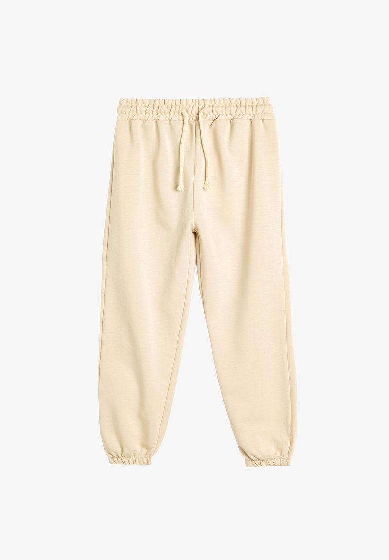 Pantalons de jogging beige avec une taille élastique, un cordon de serrage et des poignets fuselés. Fabriqués en tissu doux, avec une texture lisse et un design simple.