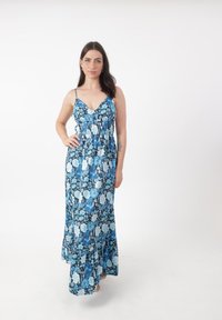 Robe maxi avec un décolleté en V, imprimé floral bleu sur fond sombre, bretelles réglables et détail à la taille froncée. Texture de tissu douce.