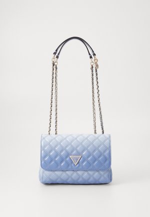 Sac à main matelassé bleu clair avec des bretelles en chaîne dorée et un logo triangulaire Guess sur le rabat avant, présenté sur un fond uni.