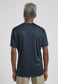T-shirt de sport à manches courtes bleu marine, fabriqué en tissu lisse et léger avec une coupe décontractée et un col rond, présentant une couture centrée au dos.