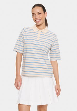 Gestreiftes Polohemd in Beige und Hellblau, aus weichem Stoff, mit einem spitzen Kragen und kurzen Ärmeln. Kombiniert mit einem plissierten weißen Rock.