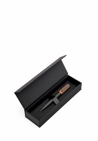 Boîte cadeau noire avec un stylo texturé gris comportant un accent et un clip marron. Le stylo est maintenu avec un ruban noir à l'intérieur de la boîte.