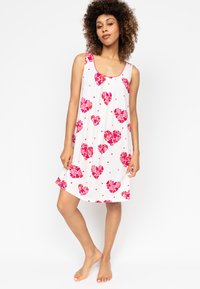 Weißes ärmelloses Kleid mit einem floralen Muster aus rosa Herzen. Weicher Stoff mit lockerer Passform, der über dem Knie endet. Keine sichtbaren Verschlüsse.