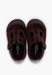 Braune Wildlederschuhe mit runder Zehenform, ausgestattet mit zwei oberen Riemen. Weicher Stoff und eine flexible Gummisohle. Innen mit "Pisamonas Barefoot" beschriftet.