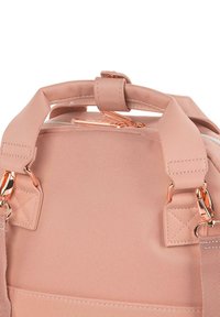 Mochila de nylon rosa con herrajes en oro rosa, asas superiores de transporte y clips laterales. Presenta una textura suave y detalles de costura reforzada.